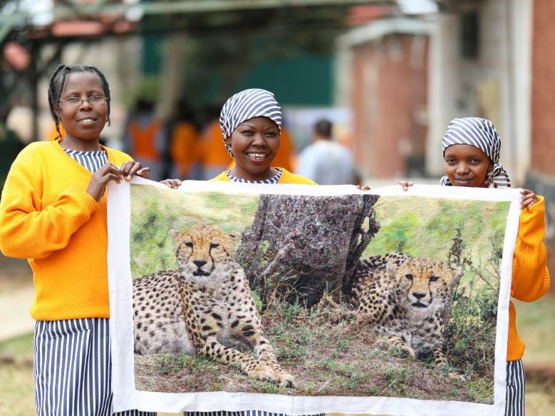 Cross Stitch International artisans presenting an artwork